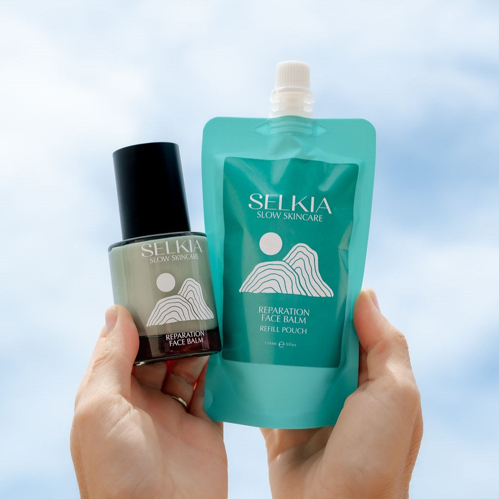 Hands holding Selkia natural face cream balm represented in refillable pouch and sustainable glass jar