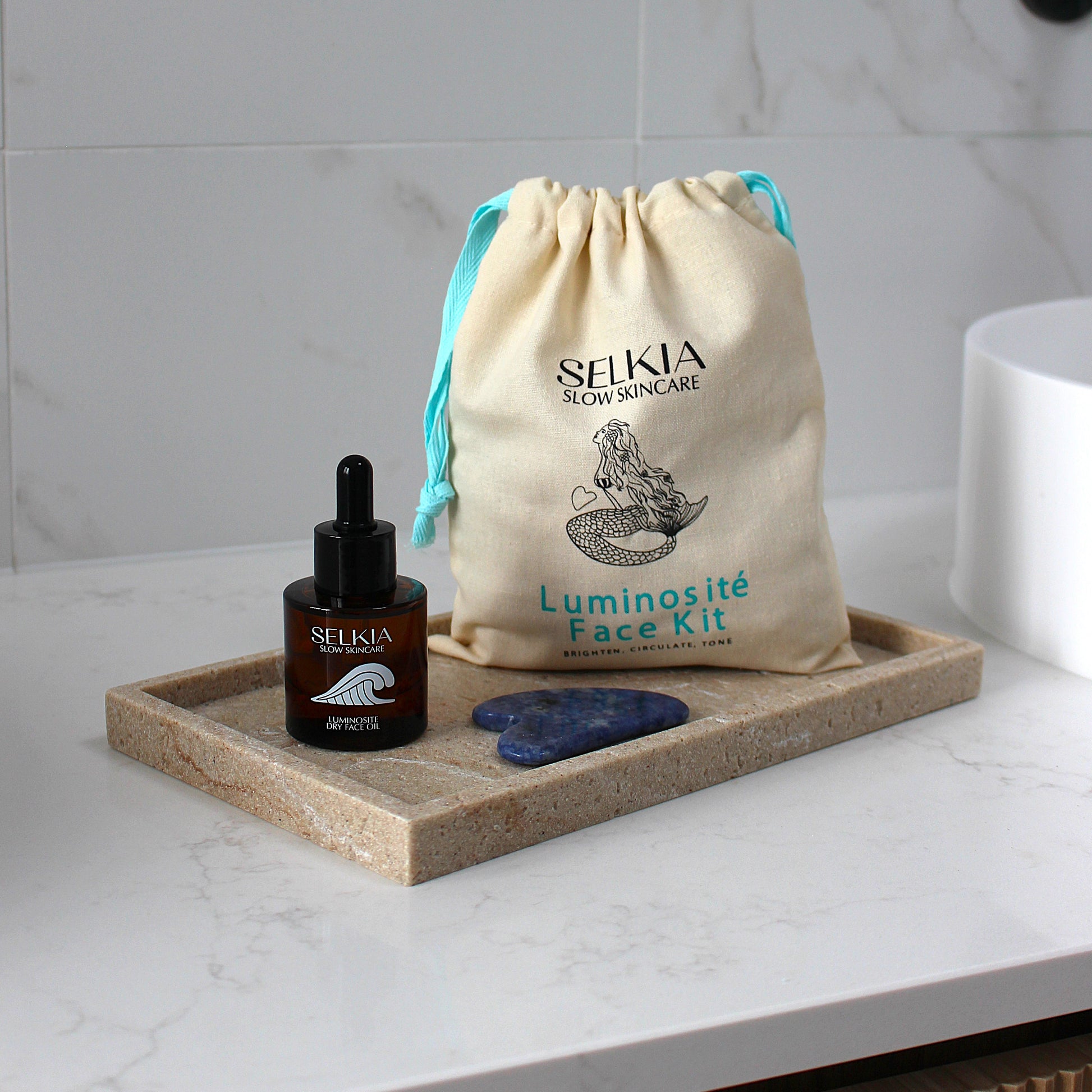 Selkia Luminosite Face Kit with face serum and stones on a marble surface