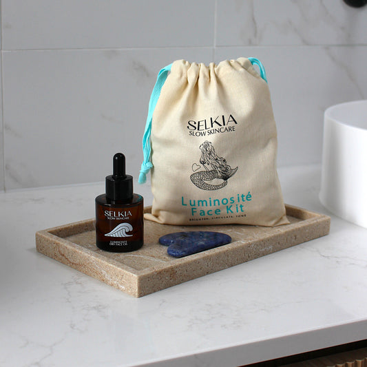 Selkia Luminosite Face Kit with face serum and stones on a marble surface