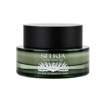 A jar of Selkia Slow Skincare Eclipse Overnight Mask, featuring a dark green translucent jar and a matte black lid, set against a plain white background.