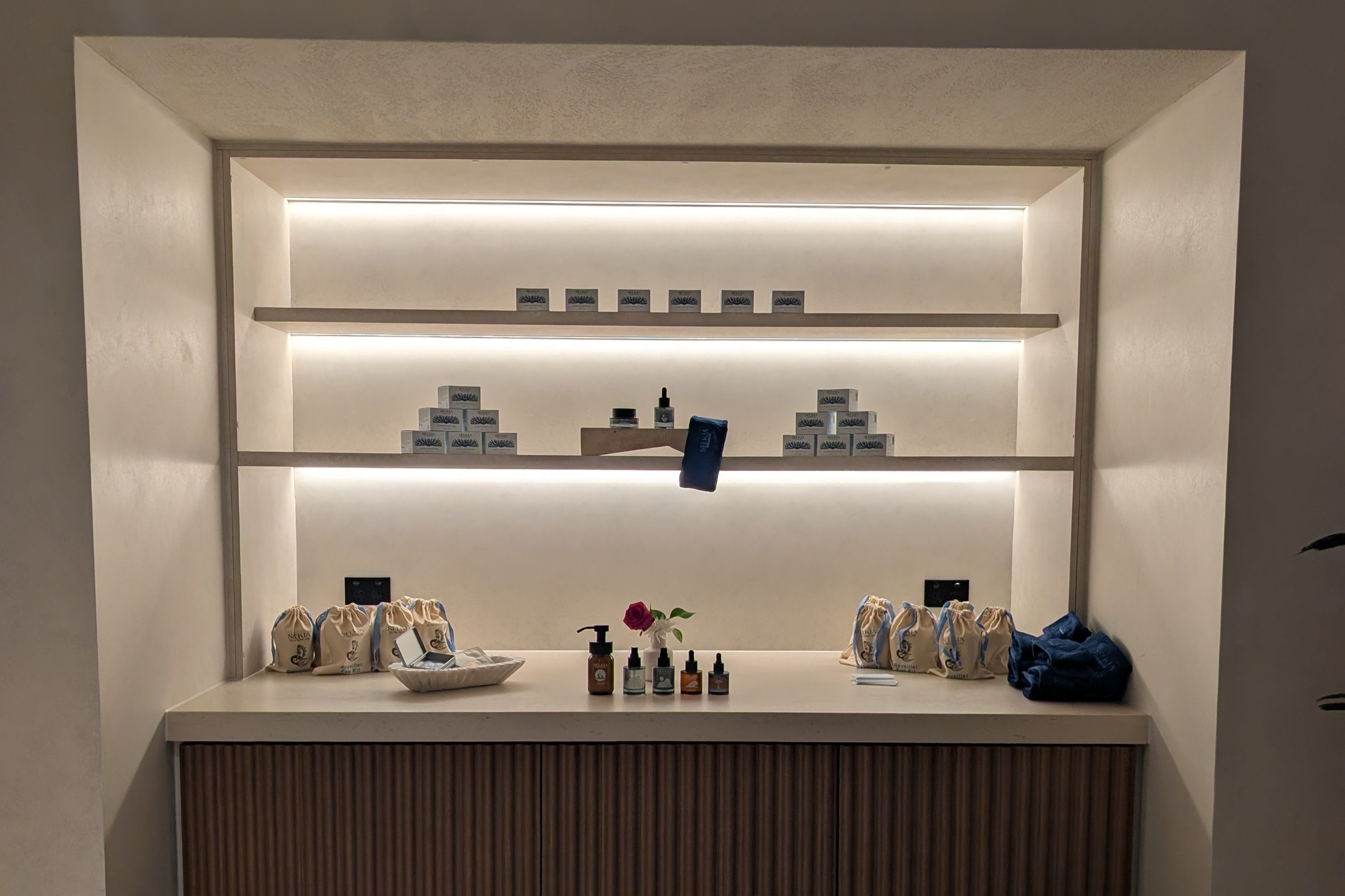 Modern bar setup with shelves and counter in a dimly lit room